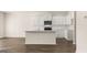 Modern kitchen boasts white cabinets, an island, and stainless steel appliances on rich, dark flooring at 325 Silver Moon Dr, Loganville, GA 30052