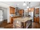 Well-lit kitchen with granite countertops, a stone-accented island, wood cabinets and stainless steel appliances at 1 Red Oak Trl, Sharpsburg, GA 30277