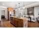 Open concept kitchen with a stone-accented island and stainless steel appliances at 1 Red Oak Trl, Sharpsburg, GA 30277