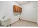 Laundry room featuring tile flooring, ample storage in the upper cabinets, and a utility sink at 1 Red Oak Trl, Sharpsburg, GA 30277