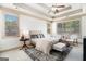 Well-lit main bedroom with a tray ceiling, fan, and lots of natural light from the many windows at 1 Red Oak Trl, Sharpsburg, GA 30277