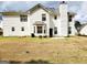 Back exterior of home with a chimney, and green grass, and a bay window at 1592 Smithson Ct, Lithonia, GA 30058