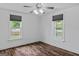 Bright bedroom featuring wood-look floors, white walls, and natural light from two windows at 1202 Emory St, Oxford, GA 30054