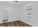Bright bedroom featuring wood-look floors, a window with blinds, and fresh white trim at 1202 Emory St, Oxford, GA 30054