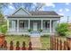 Charming home with a welcoming front porch, columns, and a quaint fenced yard at 1202 Emory St, Oxford, GA 30054