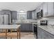 Beautiful kitchen with gray cabinetry, stainless steel appliances, and granite countertops at 1202 Emory St, Oxford, GA 30054