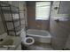 A quaint bathroom featuring original tiled walls, standard fixtures, and a storage shelf at 1243 Hill Nw St, Conyers, GA 30012