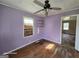 Bedroom with lilac walls, one window, a ceiling fan, and hardwood floors at 1243 Hill Nw St, Conyers, GA 30012