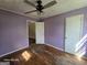 Bedroom with lilac walls, one window, a ceiling fan, and hardwood floors at 1243 Hill Nw St, Conyers, GA 30012