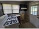 Close-up view of the kitchen with gas stove, sink, and cabinets, reflecting the need for updates at 1243 Hill Nw St, Conyers, GA 30012