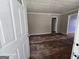 Living room with light grey walls, aged hardwood floors, and an open door at 1243 Hill Nw St, Conyers, GA 30012