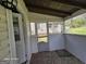 This covered porch has painted wood walls and a view of the yard at 1243 Hill Nw St, Conyers, GA 30012