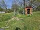 Exterior view of the backyard shed with fence and overgrown greenery at 1243 Hill Nw St, Conyers, GA 30012
