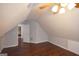 This attic has wood floors, a ceiling fan, a window, and neutral colored walls at 75 Prestwick Ln, Peachtree City, GA 30269