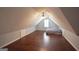 The attic has wood floors, a ceiling fan, a bed and a window at 75 Prestwick Ln, Peachtree City, GA 30269