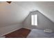 This attic has wood floors, a bed, a window, and neutral colored walls at 75 Prestwick Ln, Peachtree City, GA 30269