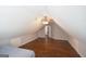 This attic has wood floors, a ceiling fan, a window, and neutral colored walls at 75 Prestwick Ln, Peachtree City, GA 30269