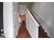 Bright hallway with hardwood floors, staircase, and a glimpse into the living room at 75 Prestwick Ln, Peachtree City, GA 30269