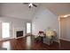 Bright living room with a fireplace, ceiling fan, wooden floors, and a door to the exterior at 75 Prestwick Ln, Peachtree City, GA 30269