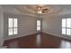 Spacious main bedroom with hardwood floors, ceiling fan and tray ceiling and bright windows at 75 Prestwick Ln, Peachtree City, GA 30269