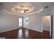 Spacious main bedroom featuring hardwood floors, tray ceiling and a view into the bathroom at 75 Prestwick Ln, Peachtree City, GA 30269