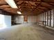 Garage with a concrete floor, exposed wooden rafters, and a white door to the outside at 1397 Iron Gate Blvd, Jonesboro, GA 30238