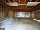 View of the garage interior featuring a concrete floor, exposed rafters, and lighting at 1397 Iron Gate Blvd, Jonesboro, GA 30238