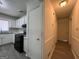 Hallway view of kitchen with white cabinets and black appliances at 1397 Iron Gate Blvd, Jonesboro, GA 30238