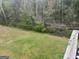 View of backyard with healthy green grass, lush trees, and fence with lights at 1461 Judson Way, Riverdale, GA 30296