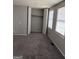 A bright bedroom with a closet and two windows, showcasing a comfortable and private space at 5575 Marbut Rd, Lithonia, GA 30058