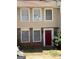 A charming townhouse with a red front door and neutral-toned siding, enhancing curb appeal at 5575 Marbut Rd, Lithonia, GA 30058