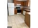 Functional kitchen with wood cabinets, white appliances, and tile flooring at 5575 Marbut Rd, Lithonia, GA 30058