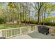 Deck with a grill overlooking a lush, green backyard surrounded by mature trees at 115 Bob White Trl, Fayetteville, GA 30215
