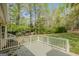 Spacious backyard view with a deck, surrounded by lush greenery and mature trees at 115 Bob White Trl, Fayetteville, GA 30215