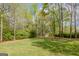 Backyard oasis featuring a lush lawn, mature trees, and a charming garden shed at 115 Bob White Trl, Fayetteville, GA 30215