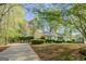 Home exterior with lush green lawn and a long driveway leading to an attached garage at 115 Bob White Trl, Fayetteville, GA 30215