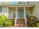 Inviting front porch with brick steps, white railings, and decorative plants in modern planters at 115 Bob White Trl, Fayetteville, GA 30215