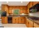 Spacious kitchen features granite countertops, wood cabinets, black appliances, and tile flooring at 115 Bob White Trl, Fayetteville, GA 30215