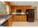 Traditional kitchen featuring wood cabinets, granite countertops, tile floors, and stainless steel appliances at 115 Bob White Trl, Fayetteville, GA 30215