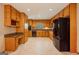 Spacious kitchen with tile flooring, wood cabinetry, granite countertops, and black appliances at 115 Bob White Trl, Fayetteville, GA 30215