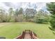 Spacious backyard featuring lush green grass, mature trees, and a charming playset at 217 Brunswick Dr, Tyrone, GA 30290