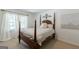 Bedroom with dark wooden four-poster bed, light walls, and neutral carpet at 217 Brunswick Dr, Tyrone, GA 30290