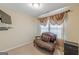Comfortable room featuring a cozy love seat, side table, soft carpet, and window with elegant drapes at 217 Brunswick Dr, Tyrone, GA 30290