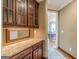View of the butler pantry with wood cabinets, granite countertops and a pass through into the dining room at 217 Brunswick Dr, Tyrone, GA 30290