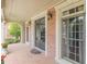 Open-air porch featuring brick flooring, classic sconce lighting, and a tranquil view of lush greenery at 217 Brunswick Dr, Tyrone, GA 30290
