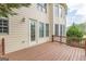 Stained wood deck on home exterior, features an entry door, windows, and traditional wall lighting at 217 Brunswick Dr, Tyrone, GA 30290