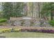 Stone entrance waterfall feature and colorful landscaping at 217 Brunswick Dr, Tyrone, GA 30290
