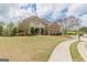 Stately brick home with well-manicured lawn, sidewalk, and mature trees creating an inviting curb appeal at 217 Brunswick Dr, Tyrone, GA 30290
