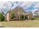 Spacious brick home with manicured gardens, mature trees, and lush green grass at 217 Brunswick Dr, Tyrone, GA 30290