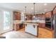 Well-equipped kitchen with wood cabinetry, granite countertops, center island, and modern appliances at 217 Brunswick Dr, Tyrone, GA 30290